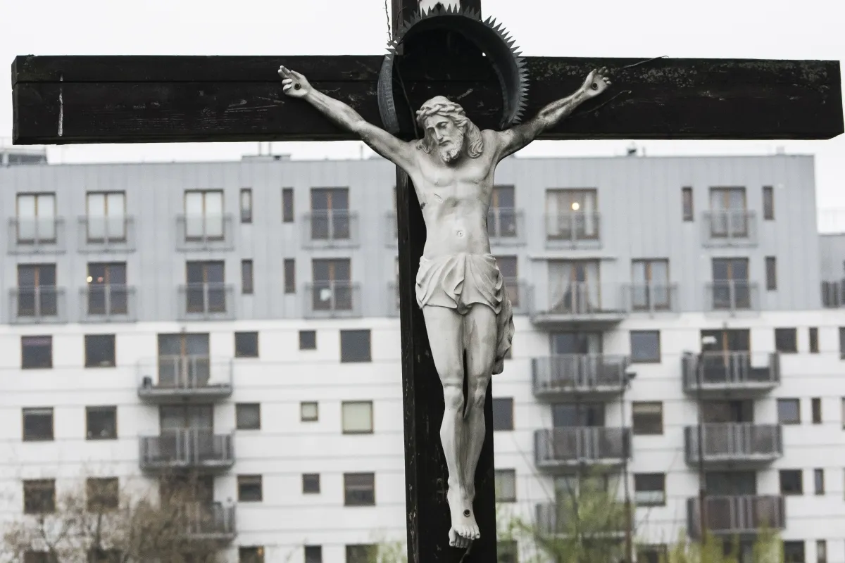 Crucifix silhouetted against apartment balconies